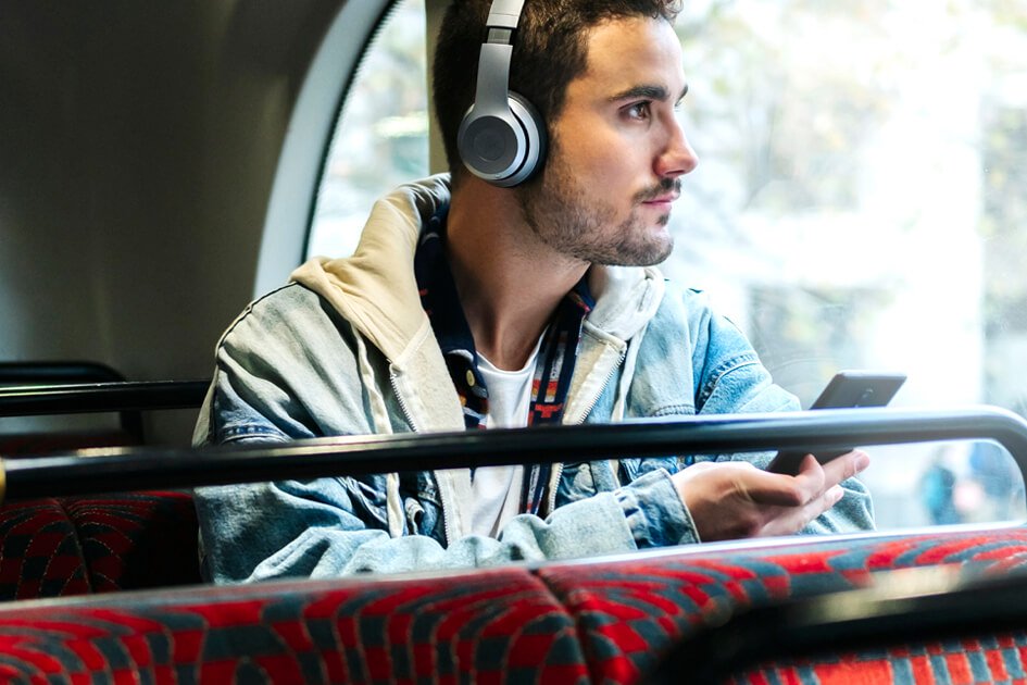 Persona con auriculares y teléfono inteligente en autobús
